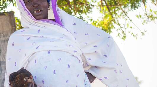 Eine Frau mit Huhn, Burkina Faso, 2018.