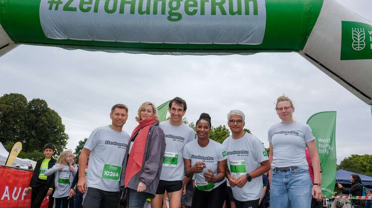 Sechs Personen posieren an der Ziellinie.