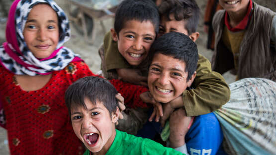 Jetzt zu Weihnachten spenden. Bildbeschreibung: Eine Gruppe lachender Kinder.