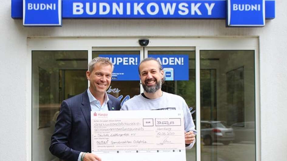 Till Wahnbaeck nimmt den Scheck von BUDNI entgegen