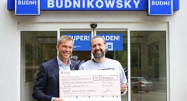 Till Wahnbaeck nimmt den Scheck von BUDNI entgegen