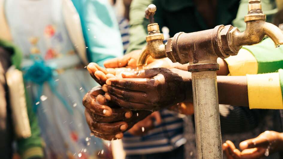 Ein Mädchen wäscht sich die Hände an einem Wasserhahn in Sodo, Äthiopien.