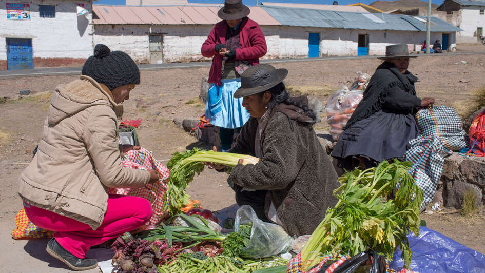 Indigene Menschen handeln mit Gemüse auf einem Markt im peruanischen Huaracco.
