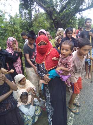 Flucht der Rohingya 1 Rohingya auf der Flucht nach Bangladesch. Eine Mutter trägt ihr Kind auf dem Arm.