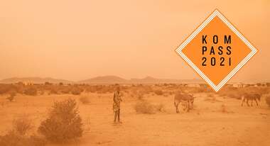 Dürre in Somaliland: Ein Junge mit zwei Eseln steht in einer kargen Landschaft. Oben rechts ist das "Kompass 2021" Logo.