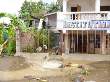 Mann und Kind versuchen mit Eimern Wasser aus ihrem Haus zu bekommen