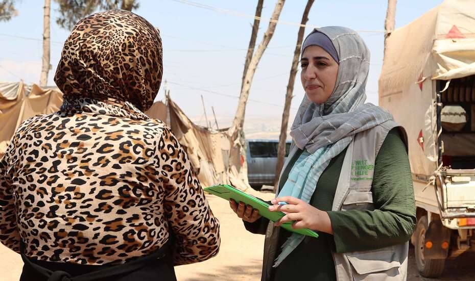 Welthungerhilfe-Mitarbeiterin im Gespräch mit einer Frau in einem Flüchtlingslager in Syrien