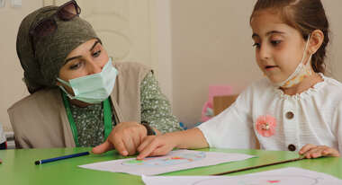 Eine Frau und ein Kind sitzen nebeneinander.