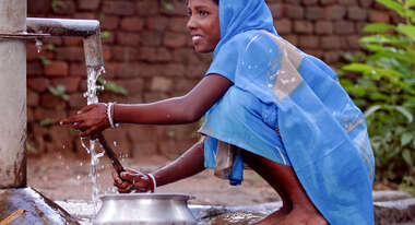 Ein Mädchen wäscht an einem Brunnen, Indien, 2008.