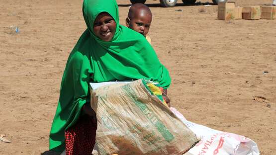Eine Frau nimmt eine Lebensmittelration in Empfang