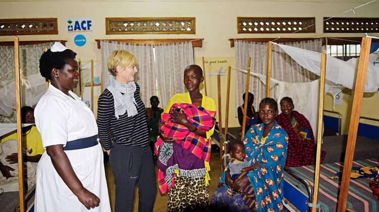 Schauspielerin Gesine Cukrowski, eine Krankenschwester und mehrere Frauen. Im Hintergrund sieht man Betten.