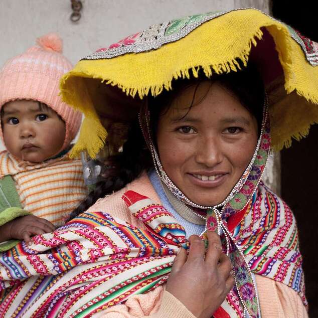 Eine Frau aus Peru trägt ihr Kind auf dem Rücken.