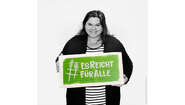 Schauspielerin Nadine Wrietz hält ein Schild mit dem Welthungerhilfe-Hashtag #EsReichtFürAlle.
