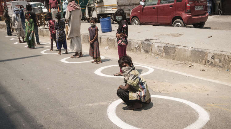 Menschen in Delhi, Indien stehen für Lebensmittel an.