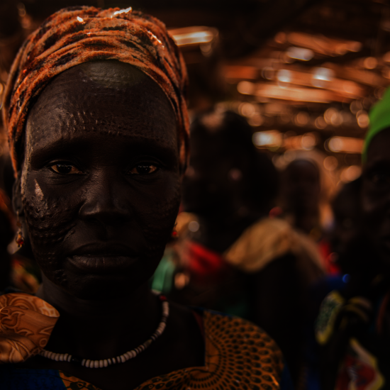 Eine südsudanesische Frau schaut im Porträt direkt in die Kamera.