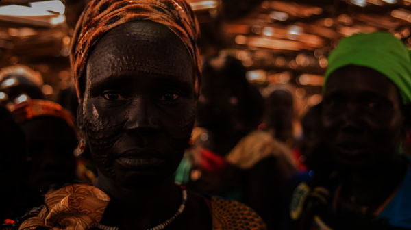 Eine südsudanesische Frau schaut im Porträt direkt in die Kamera.