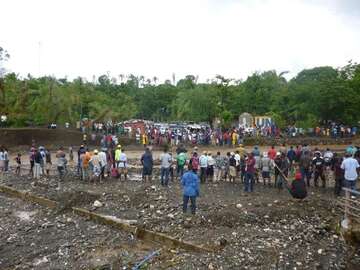 Einwohner stehen am Rand eines Flusses