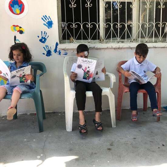 Kinder lesen draußen Comics, Türkei 2020.