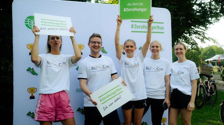 Teammitglieder halten Schilder mit der Aufschrift "ZeroHungerRun - Ich war dabei!" hoch
