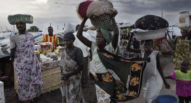 Frauen tragen Körbe 