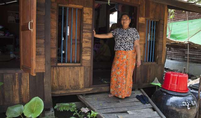 Frau steht vor Hütte
