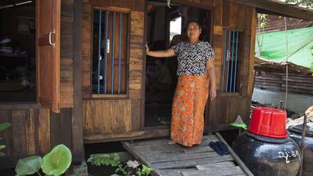 Frau steht vor Hütte