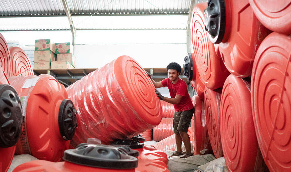 Ein Mann inmitten von großen roten Wassertanks.