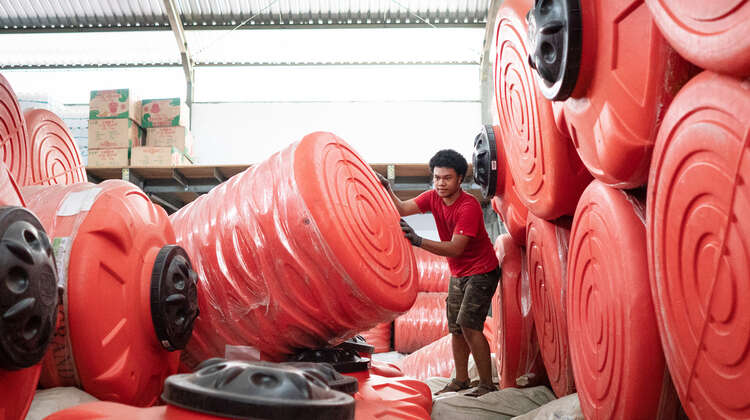 Ein Mann inmitten von großen roten Wassertanks.