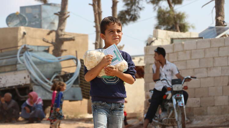 Ein Junge trägt Brot, Syrien 2019.