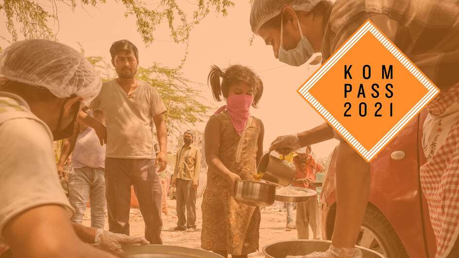 Corona-Krise in Indien. Ein Mädchen mit Mund-Nase-Schutz hält einen Teller und einen Topf, in welchen ein Mann Essen füllt. Oben rechts ist das Kompass 2021 Logo.