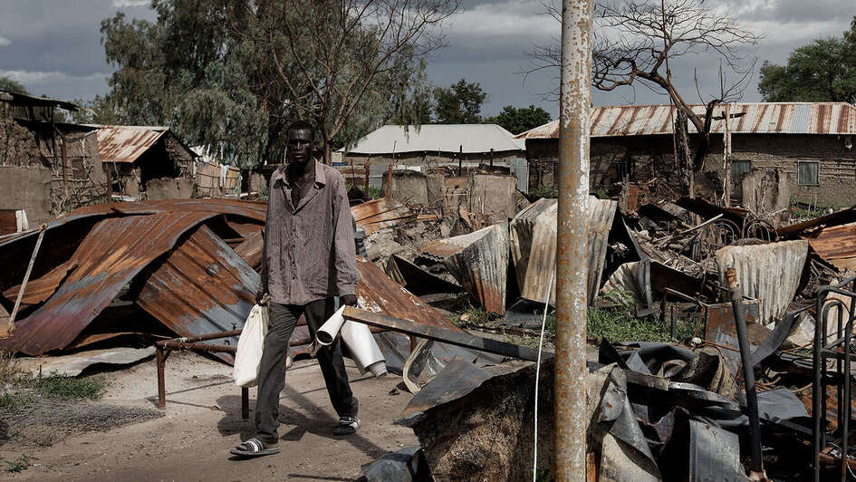Ein Mann im Südsudan läuft durch die Trümmer einer Wohnsiedlung der Stadt Malakal.