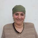 Eine Frau vor einer weißen Häuserwand, Tadschikistan 2021.