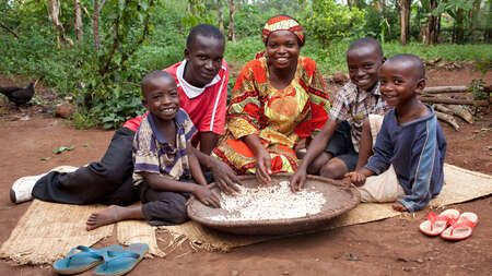Mutter und ihre vier Kinder sitzen um eine Schüssel und lächeln für das Foto.