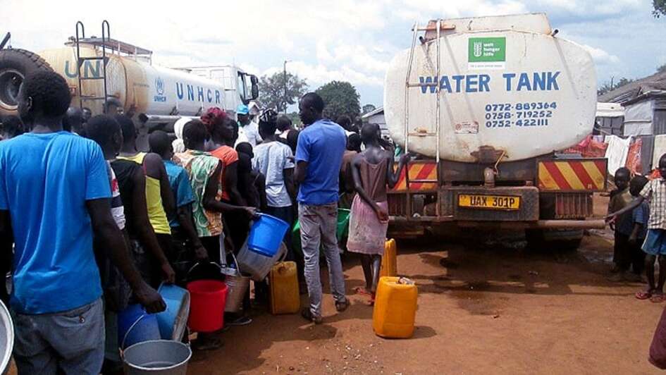 Flüchtlinge stehen für Wasser an