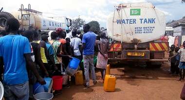 Flüchtlinge stehen für Wasser an