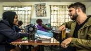 Robert Redweik mit einer Frau vor einer Nähmaschine während eines Besuchs des "Skill up!"-Projekts in Nairobi, Kenia.