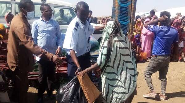 Männer und Frauen mit Nothilfe-Paketen