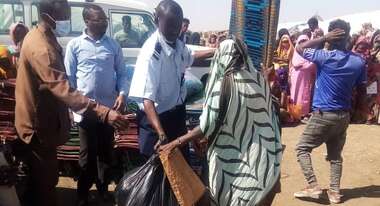 Männer und Frauen mit Nothilfe-Paketen