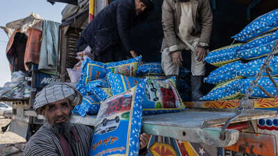 Drei Männer laden einen Lastwagen aus.