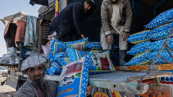 Drei Männer laden einen Lastwagen aus.