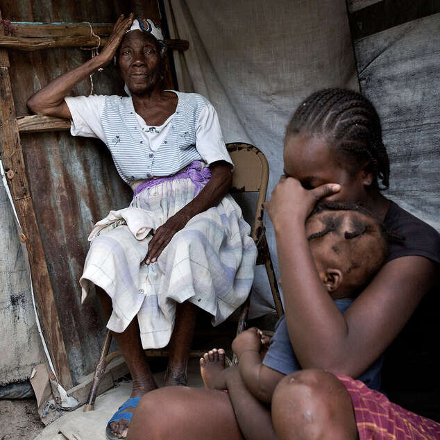 Großmutter und zwei ihrer Enkelkinder harren in einem Zeltlager in Port-au-Prince, Haiti aus