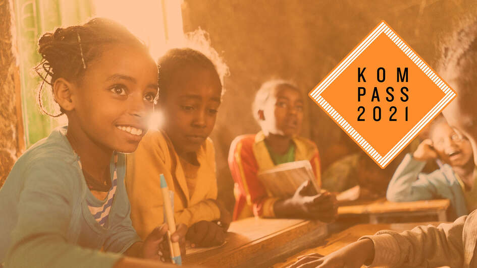 Mehrere Mädchen mit Schulbüchern und Stiften beim Unterricht. Oben rechts ist das "Kompass 2021" Logo.