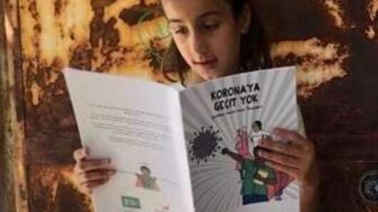 Ein Mädchen liest in einem Heft.