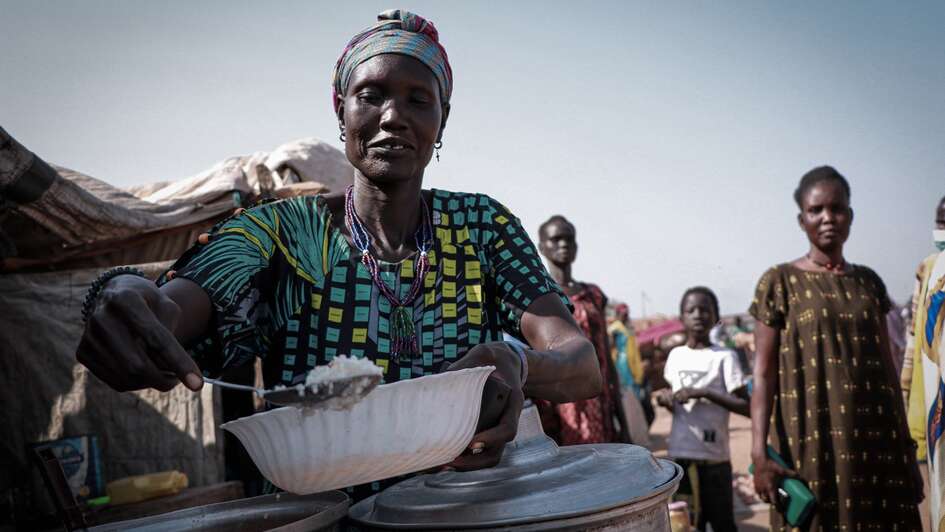 Eine Frau füllt eine Schüssel mit Reis.