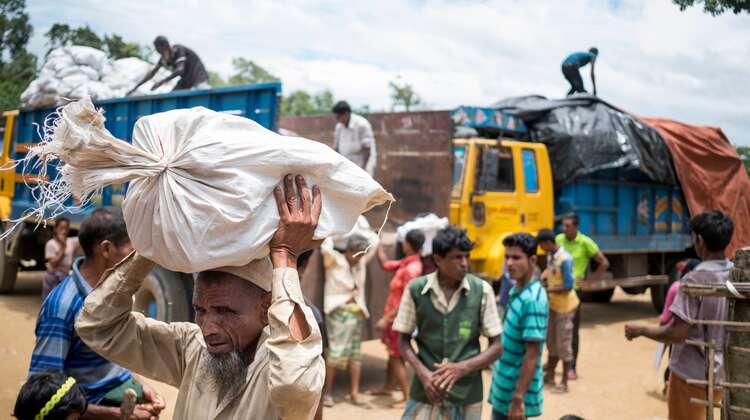 Ein Mann trägt einen Sack mit Brennmaterial im Camp Hakimpara, Bangladesch, August 2018.