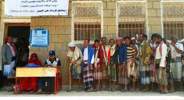 Menschen stehen bei einer Bargeldverteilung Schlange. 