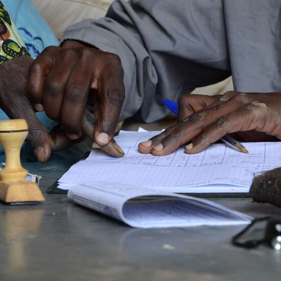 Verteilung von Hirse in Niger, 2012. Der Empfang wird per Fingerabdruck auf einer Liste bestätigt.