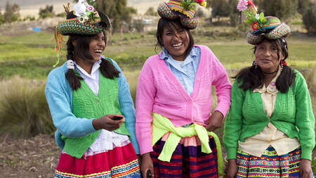 Drei junge Frauen in peruanischer Tracht bei der Gemeinschaftsarbeit