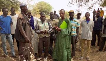 Massiga steht zusammen mit Menschen aus seinem Dorf © Schwenk