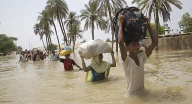 Überschwemmung in Pakistan: Familien kämpfen sich durch die Wassermassen.